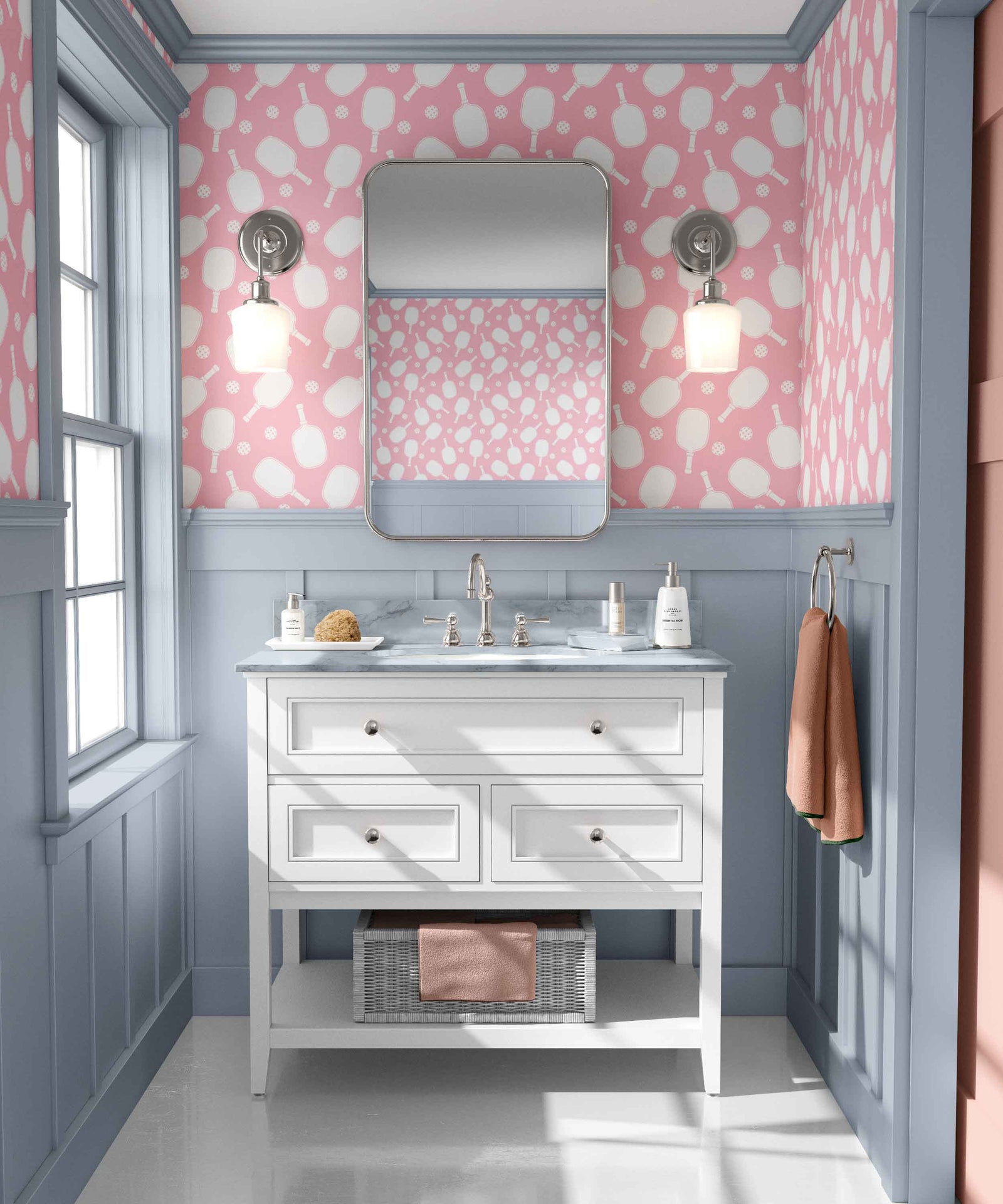 pink_Pickleball paddles in white on a pink background in a bathroom with blue wood panels and white vanity