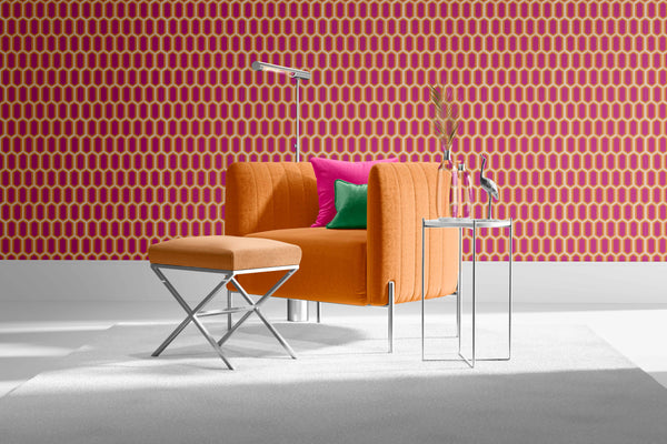 brights_Modern orange sofa with colorful cushions against a patterned pink wall.