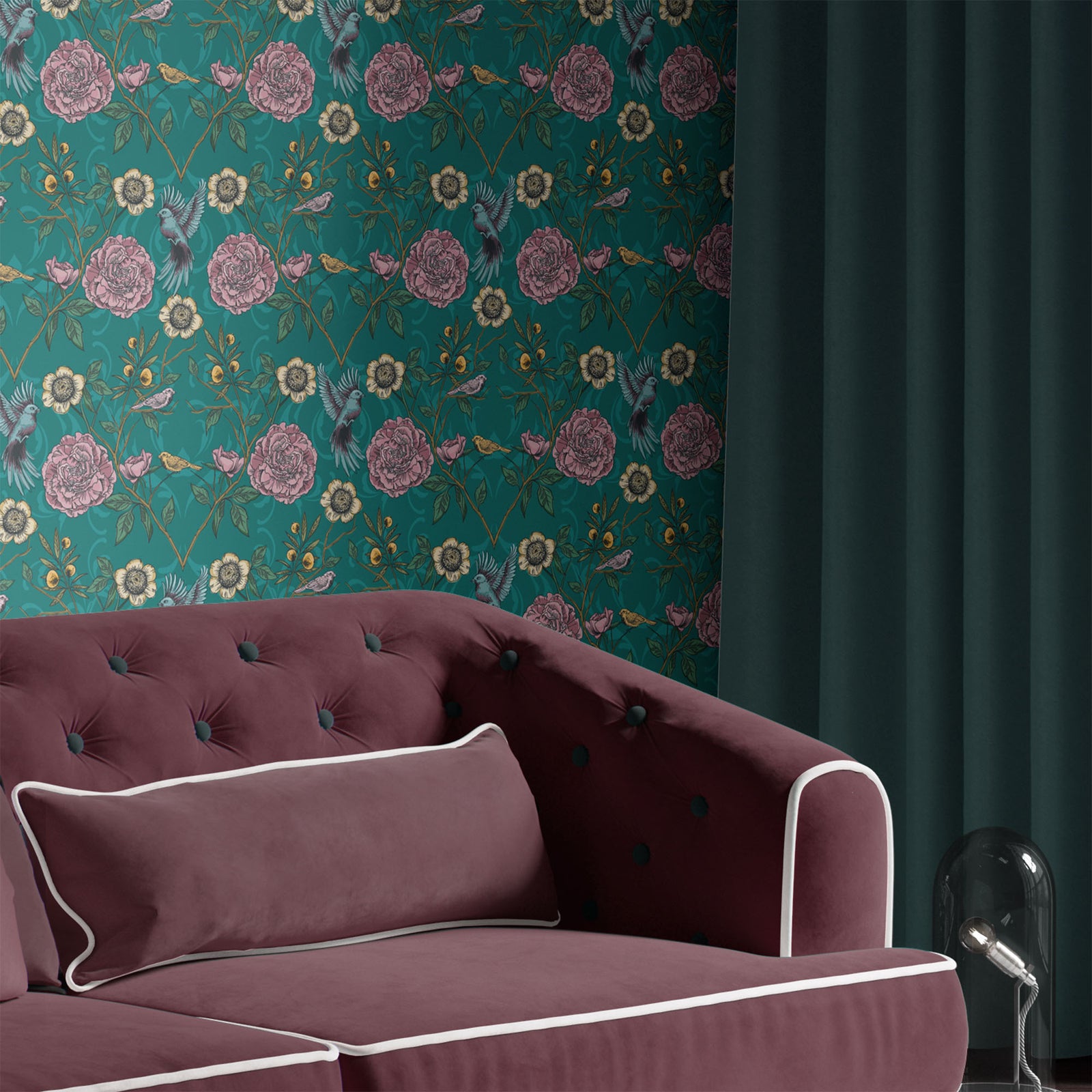 teal_A roll of wallpaper featuring a floral and bird pattern on a teal background in a room with a maroon couch.