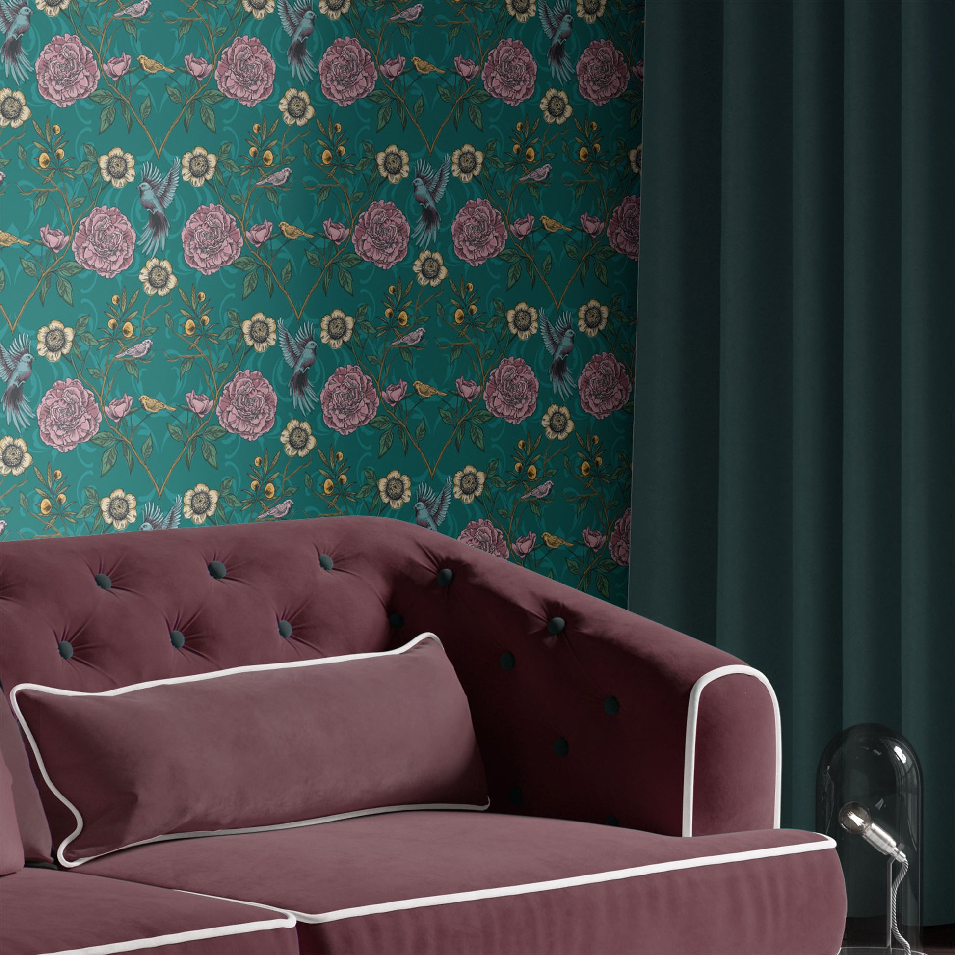 teal_A roll of wallpaper featuring a floral and bird pattern on a teal background in a room with a maroon couch.