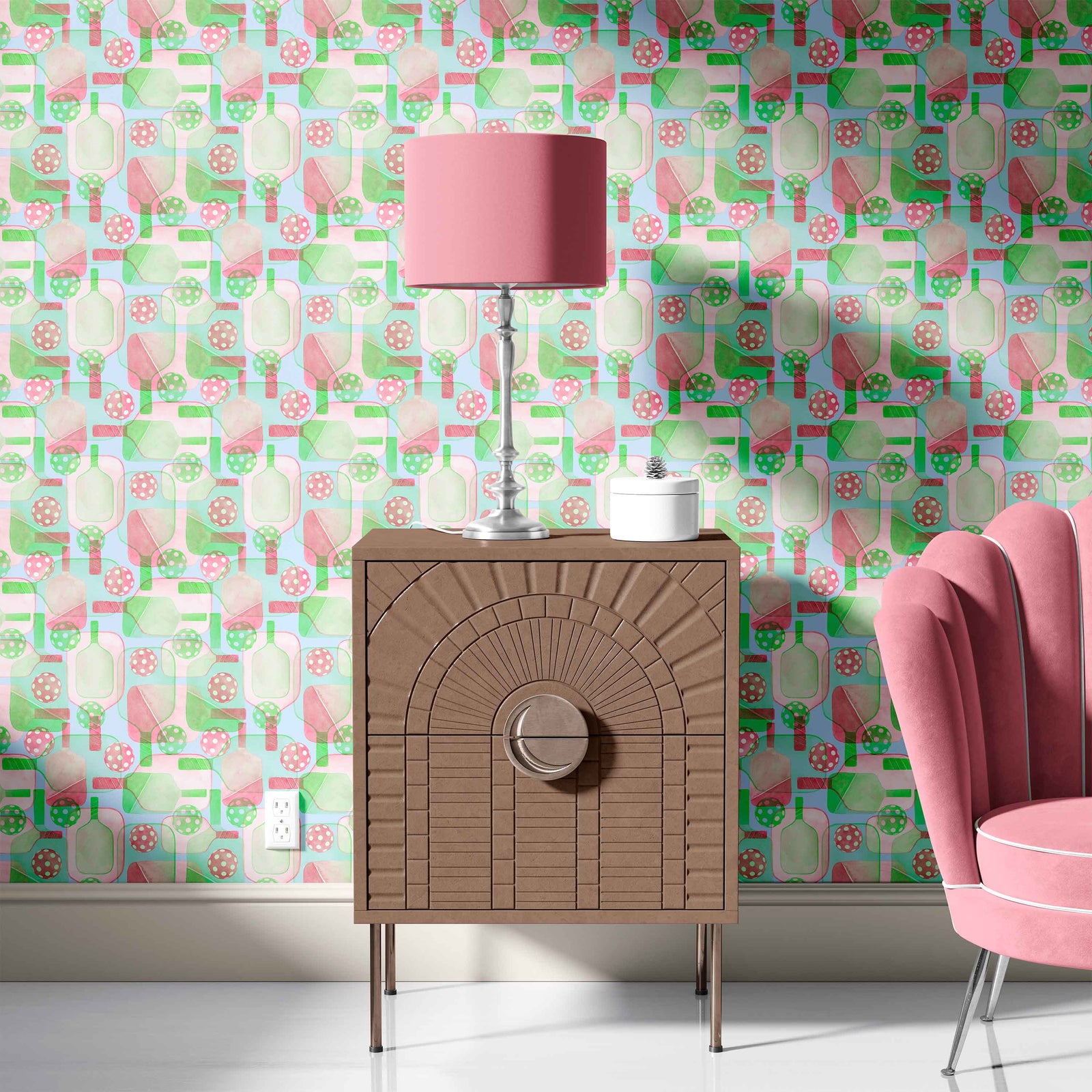 pink_A wallpaper pattern that includes abstract representations of pickleball paddles and balls in green, blue, and pink colors on a light background in a room with a pink couch.